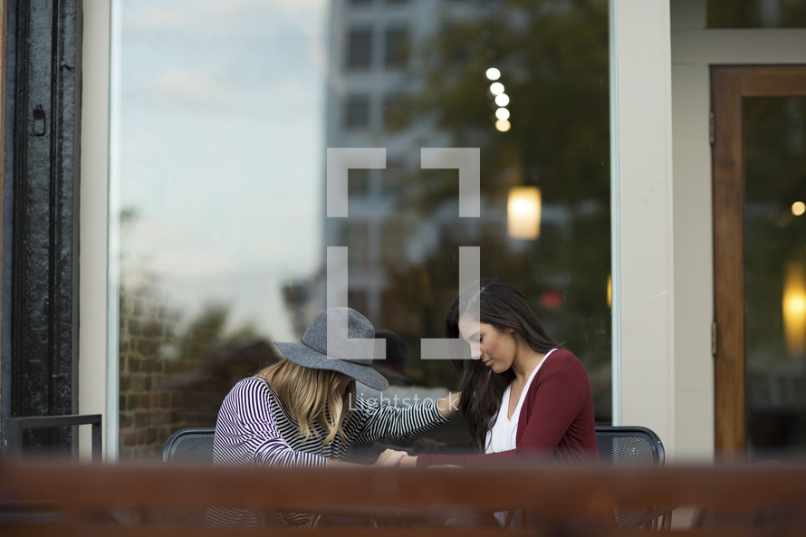 two friends praying together in a city.