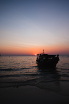 boat beached on a shore at dusk 