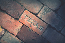 Texas stamp on a red brick 