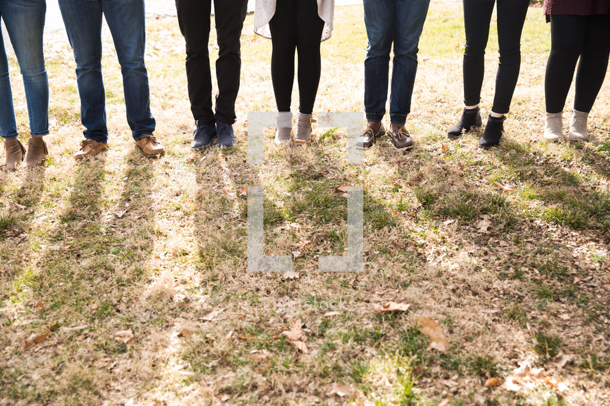 legs of a group standing in grass