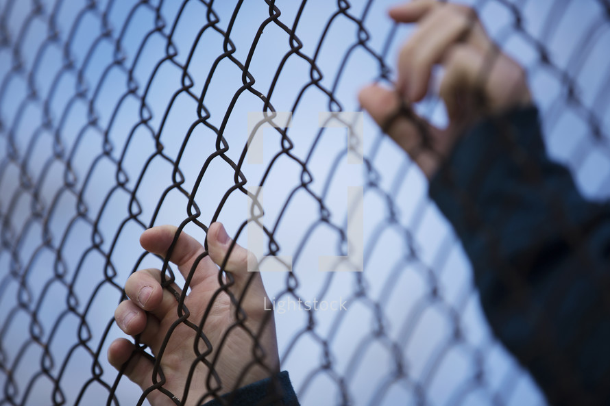 hand on a chain link fence 