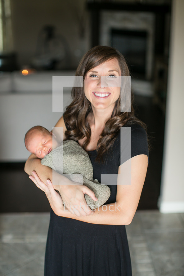 mother holding a swaddled newborn 