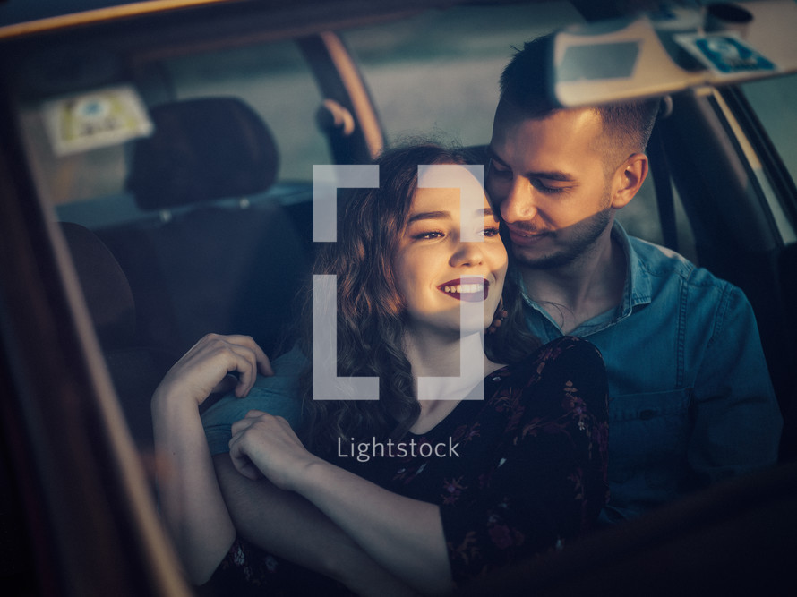 couple sitting in a car snuggling 