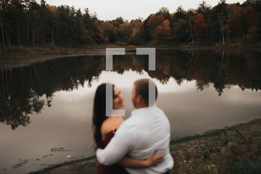 couple standing in front of a pond 