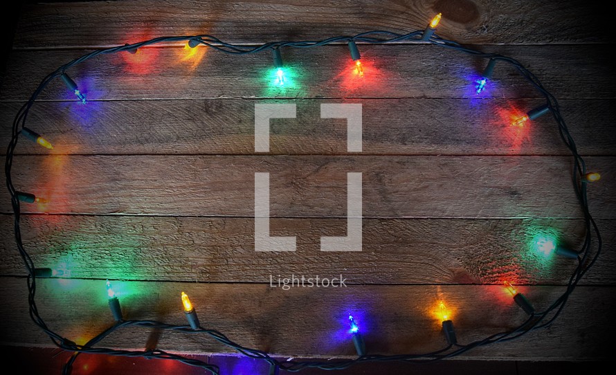Border of Christmas Lights on wooden background (Dark Vignette)