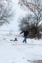 father and son sledding in the snow 