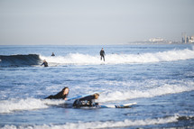 surfers catching waves in Newport Beach, CA