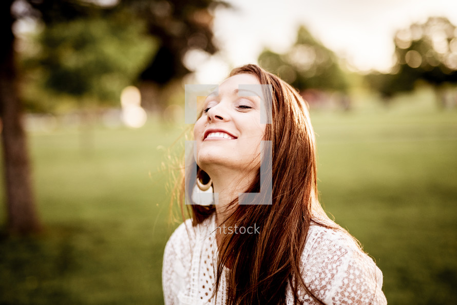 a woman with eyes closed smiling with head turned to God 
