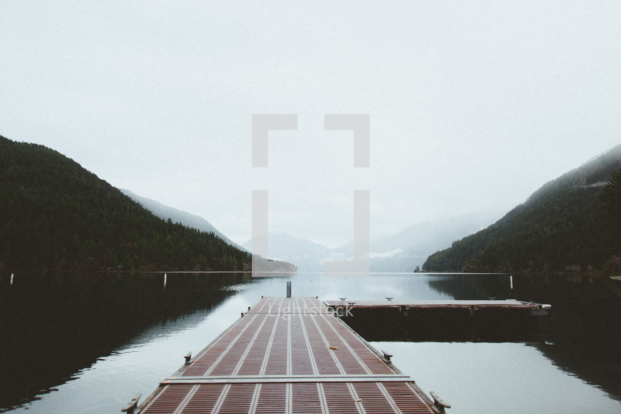 a dock over a foggy lake 