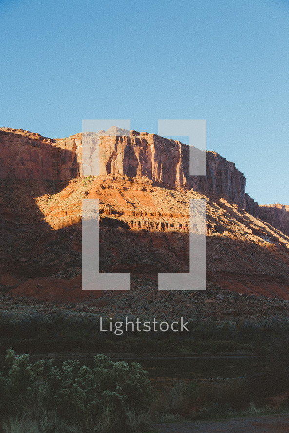 sunlight shining on a red rock mountain 
