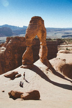 people near a arched rock formation 