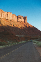 red rock cliffs and rural road 