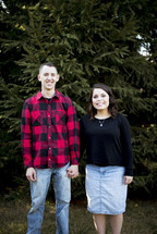 couple portrait in a Christmas tree lot 