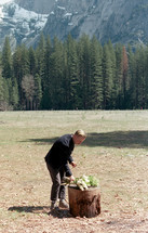 a man picking up a bouquet of flowers 