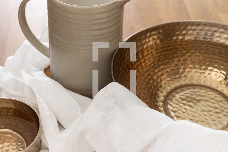 Water pitcher and copper bowls with a white linen cloth with copy space