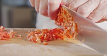 Slow motion close up of a chef knife slicing a Red bell pepper