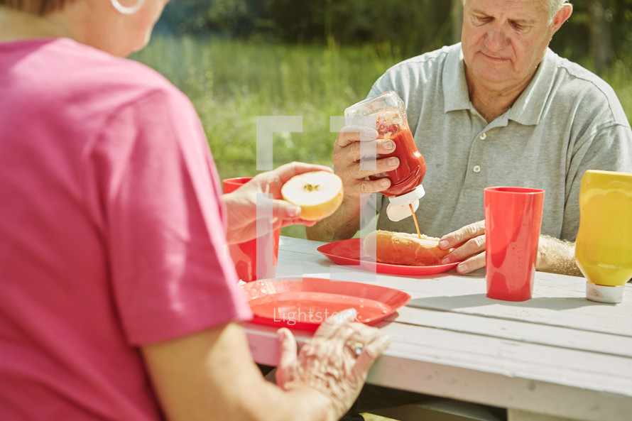 grandmother and grandfather eating at a picnic table