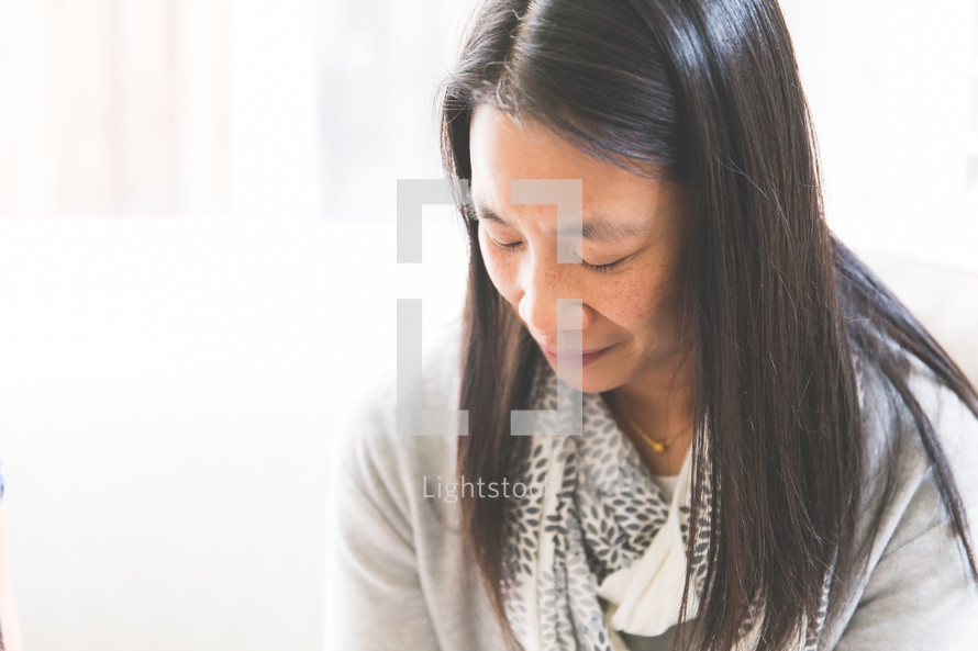head shot of an Asian woman praying 