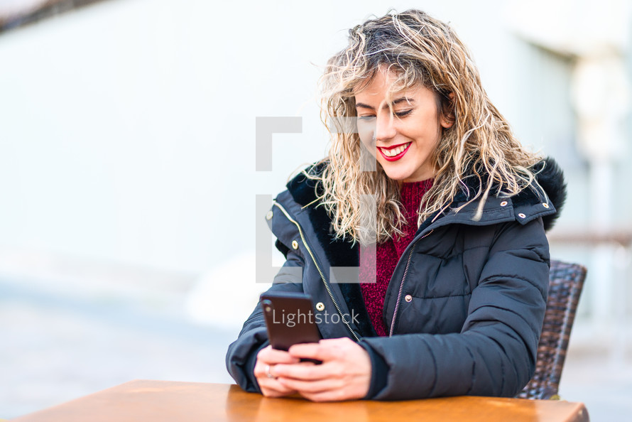 smiling woman looking at a cellphone 