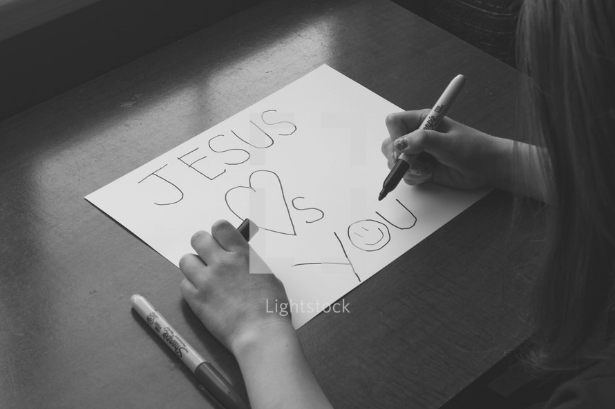 Girl writing Jesus loves you 