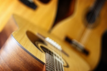 A trio of acoustic guitars (standard six string in foreground, classical six string and a twelve string in background) are combined to create a music themed image that can signify more traditional worship bands, praise songs, church music, etc. - shallow depth of field on foreground six string. 