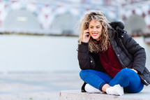 curly blonde woman sitting on bench. Casual clothes