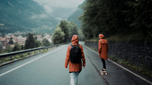 couple in rain gear walking down a rural road 
