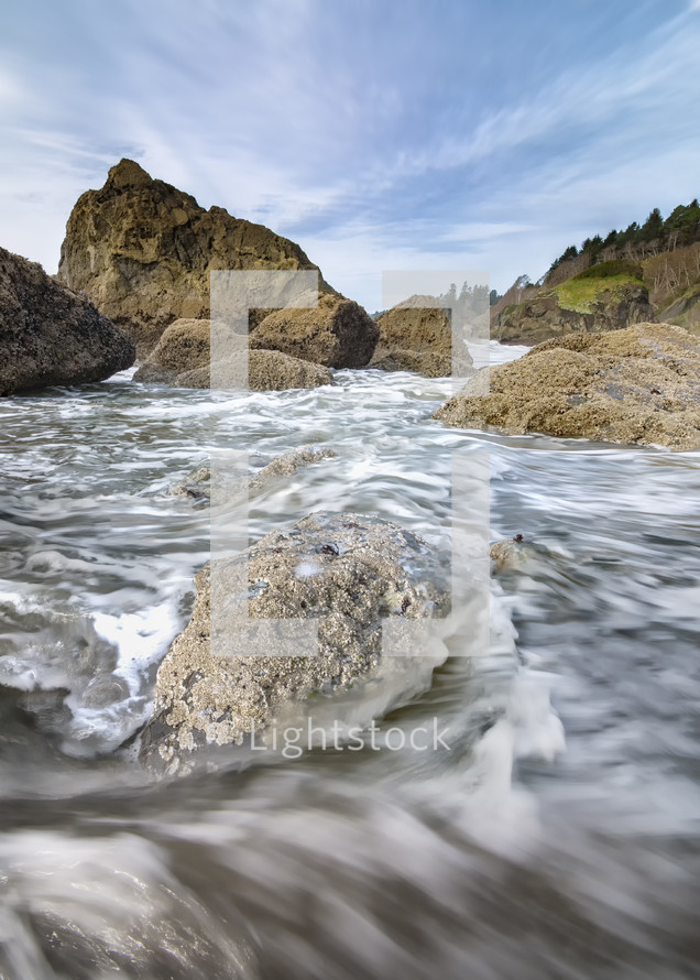 tide flowing through rocks onto a shore 