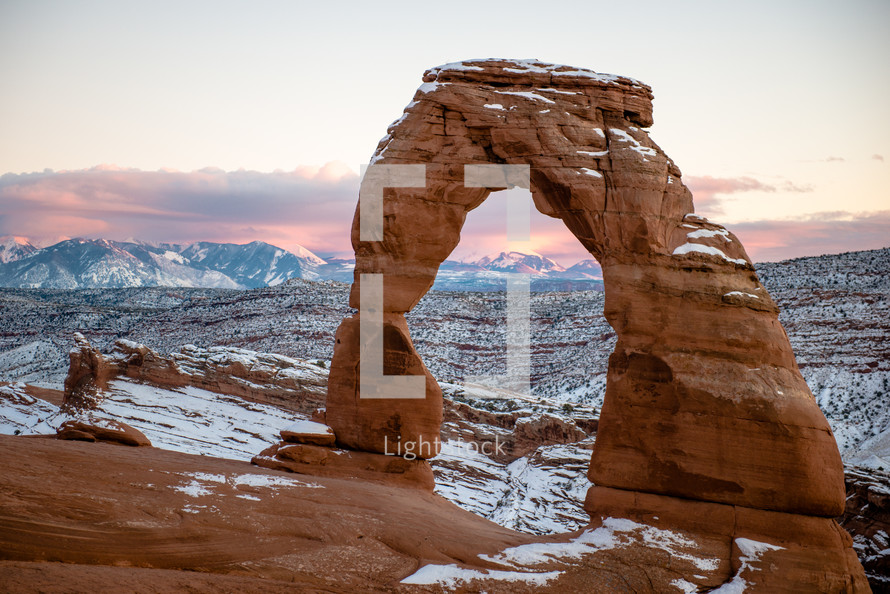 Delicate Arch in Utah taken with snow on it right after sunset.