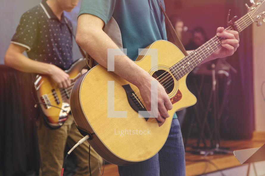 worship practice with acoustic guitar and bass on stage