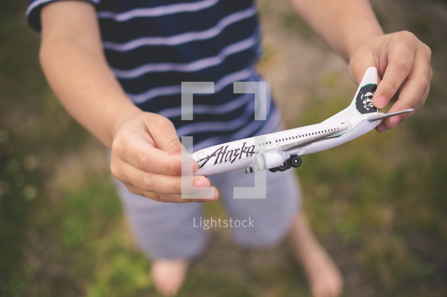 boy child holding a toy airplane 