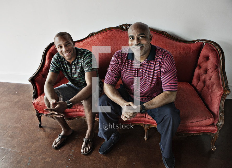 two men sitting on couch