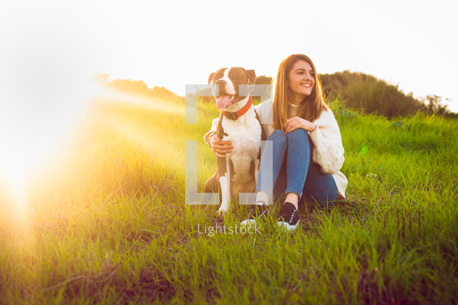 Young woman sitting with American Staffordshire terrier