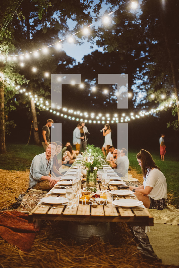 Guests at an outdoor evening dinner party.