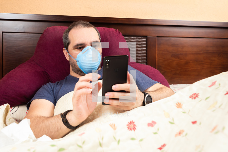 sick man with a cellphone in bed 