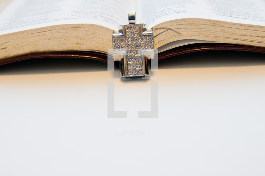 diamond studded cross necklace on a Bible
