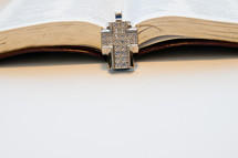 diamond studded cross necklace on a Bible