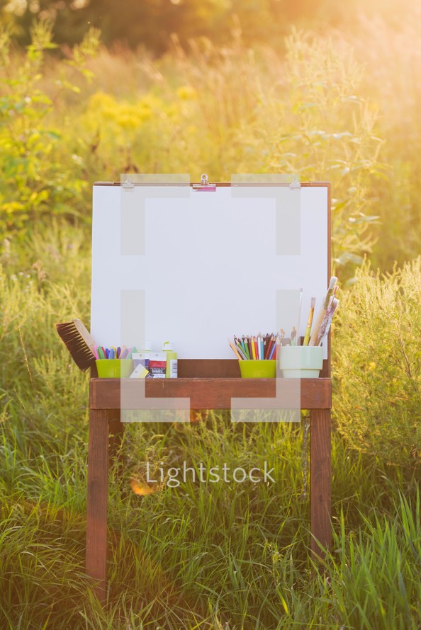 easel and paint and blank canvas outdoors 