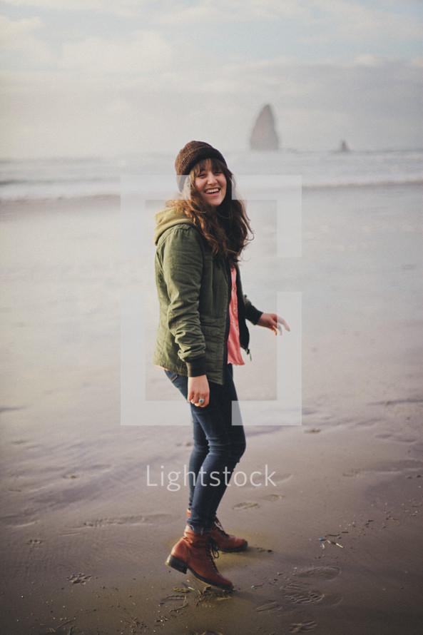 woman walking on a beach wearing boots 