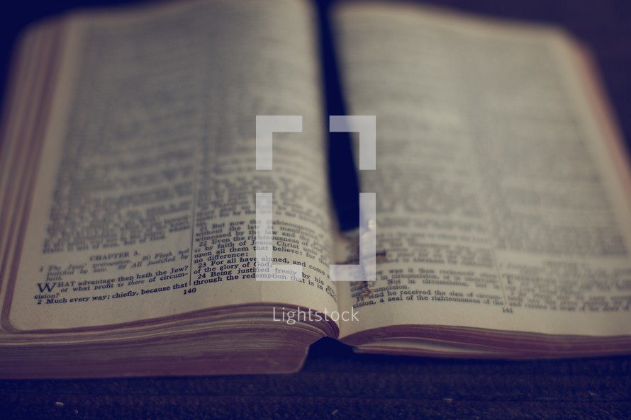 The open Bible with a cross as a bookmark 
