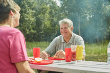 grandmother and grandfather eating at a picnic table