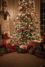 gifts around a Christmas tree and stockings by a fireplace