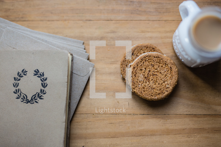 Cookies and milk next to stationery on a wooden table.