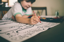 boy child coloring with crayons 
