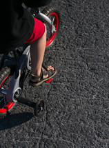 boy child riding a bike with training wheels