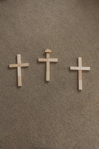 three crosses made of wooden blocks on carpet 