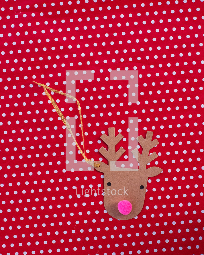 reindeer Christmas ornament on red and white polka dot background 