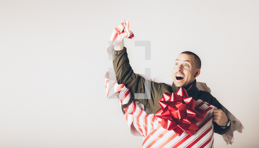 A man breaks free from wrapping paper