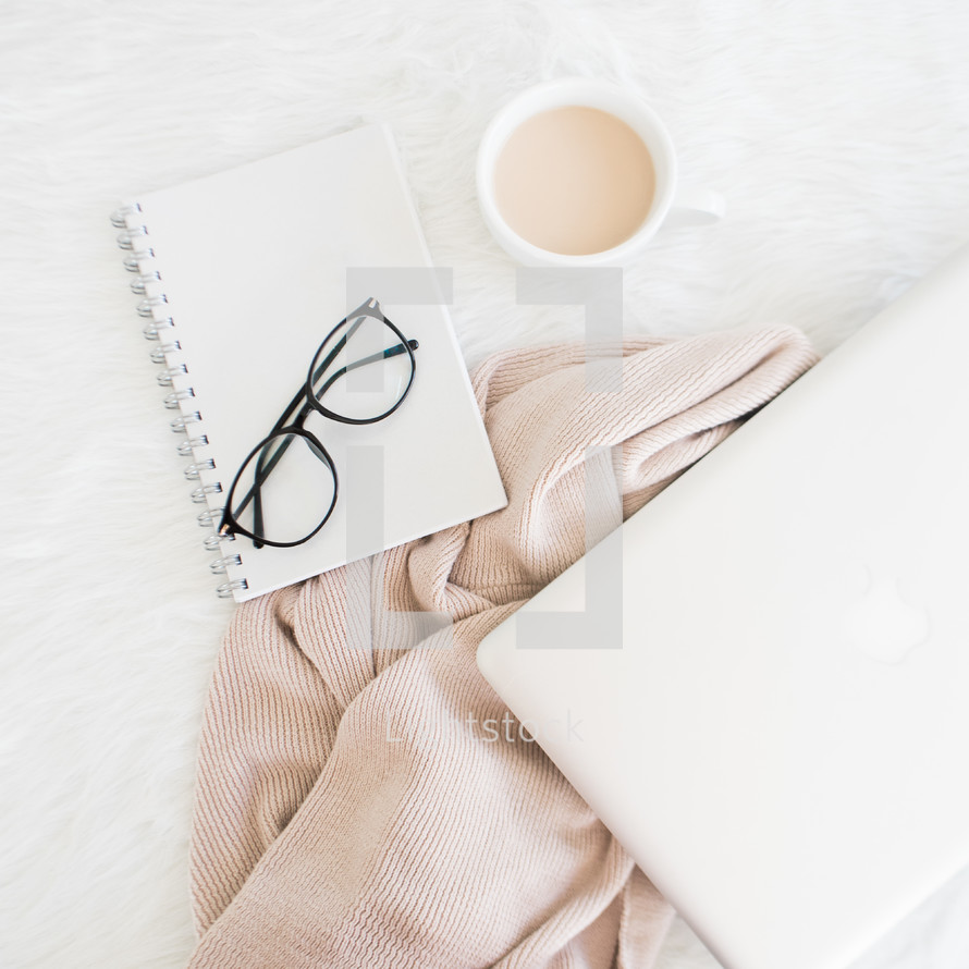 laptop computer, reading glasses, and journal on a blanket 