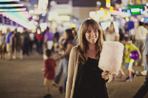 woman holding cotton candy at a fair